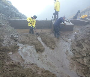 Robbie, Terry and Nick clearing the silt using shovels in the dam