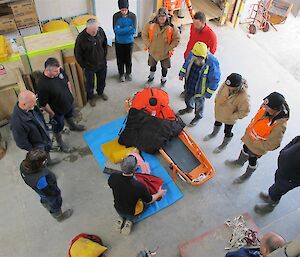 A group of expeditioners standing around a stretcher