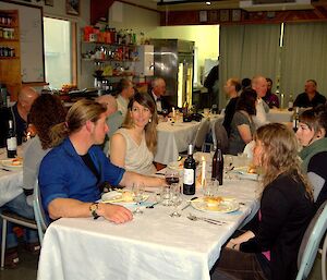 The mess hall filled with tables and expeditioners sitting down to a nice dinner