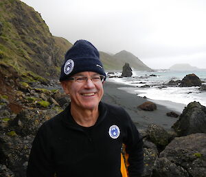 Malcolm standing on the beach with east coast in background