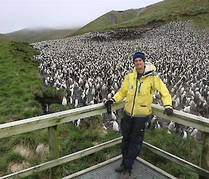 Tim in yellow jacket standing in front of Royal penguin colony