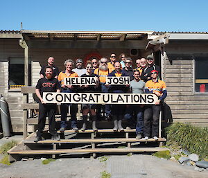 The Macca crew holding a congratulations sign