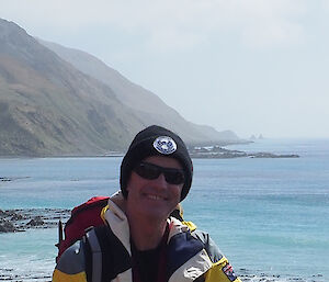 Terry on the East Coast, smiling at camera with ocean behind