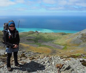 Rowena standing on escarpment with ocean in rear