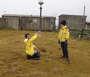 Incoming weather observer Marty checking a weather gauge with outgoing observer Louise as part of their handover