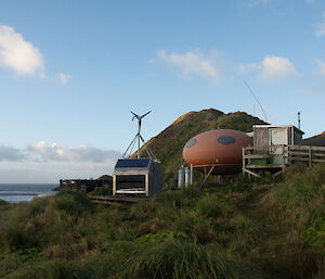 The ‘smartie’ shaped Brothers Point Hut sitting on the hillside