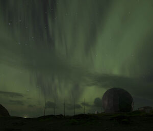 Aurora dancing in the sky over the dome of the ANARESAT