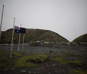 Flag at half mast with station in background.