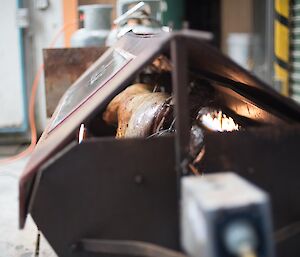 A lamb cooking on a spit roast