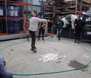 A man is leaping in the air as he spins coins in a ring while playing 2-Up