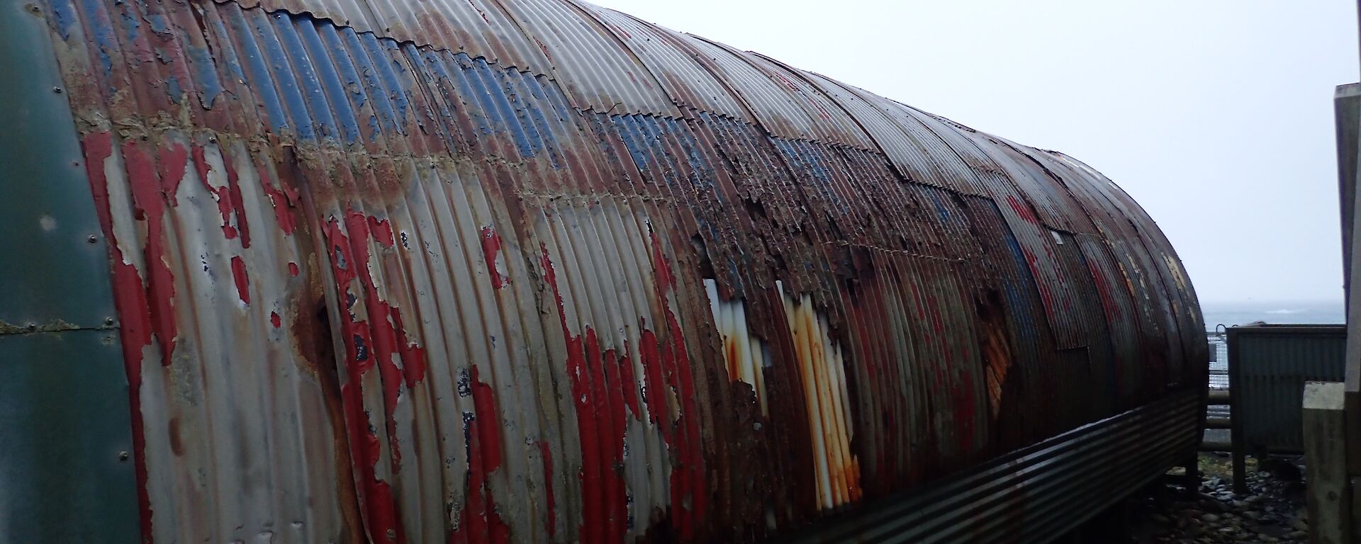 A very rusty, multicoloured shed wall.