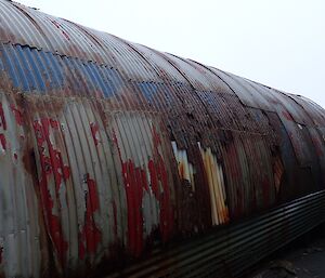 A very rusty, multicoloured shed wall.