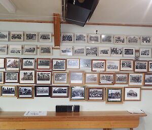 Rows and rows of photos of groups of people on a wall.