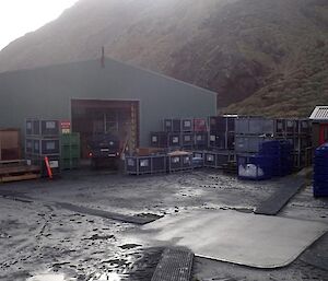 The shed that is the green store surrounded by containers