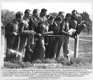 A photo of the men of the 1951 ANARE leaning on a fence