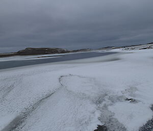 Snowy plateau with lake in foreground