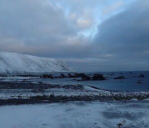 A view out along the beach to the headland with everything covered in snow