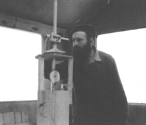 A B&W photo of a man using a magnetometer in 1954