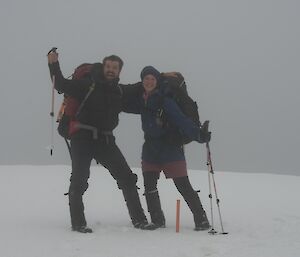 Two people smiling at camera in the snow