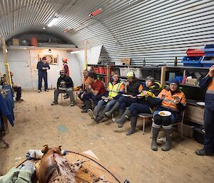 A group of people eating in the shed