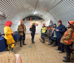 People are gathered inside a Nissen hut