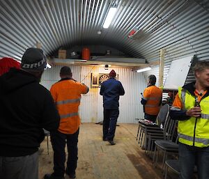 A group of people in the hut playing darts