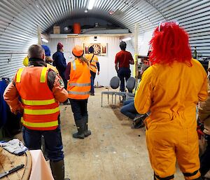 A rear view of everyone watching the dart board