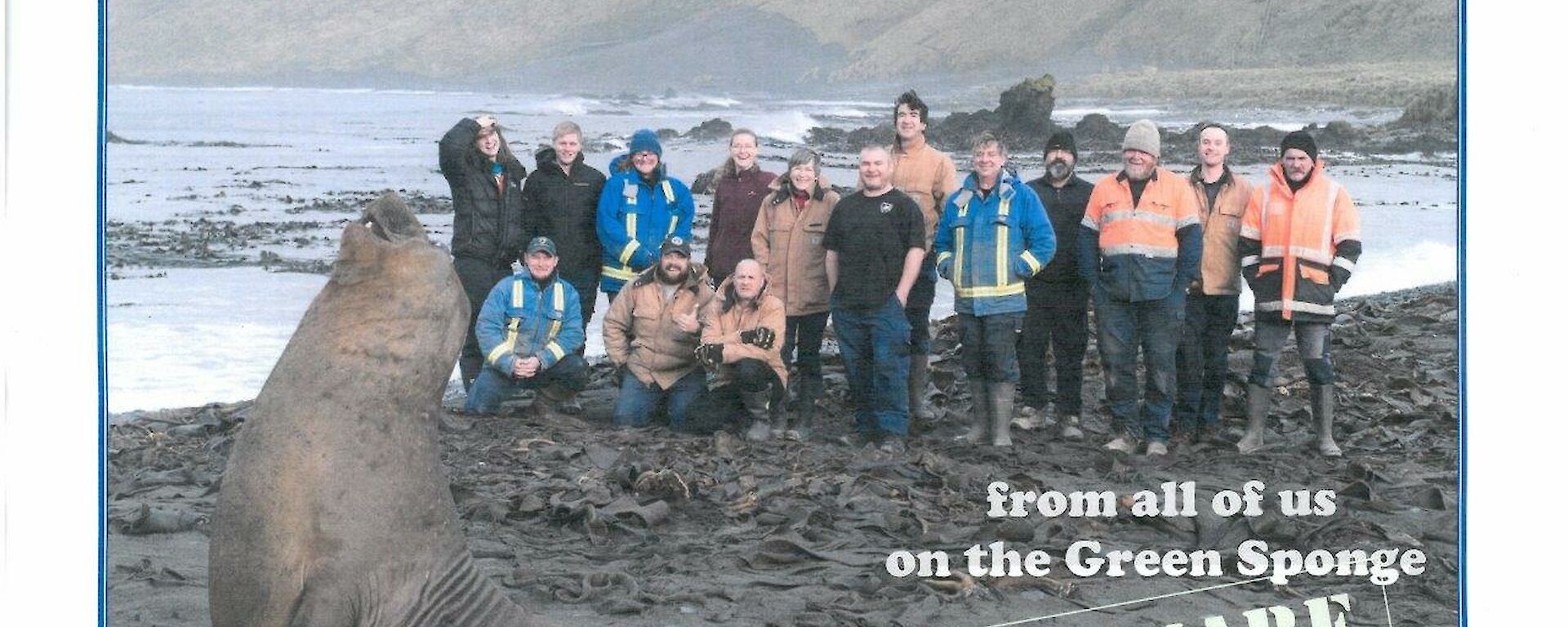 A group photo of the macquarie Island winterers with an elephant seal in foreground