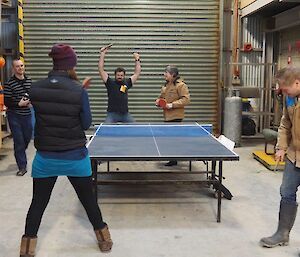 4 people playing ping pong
