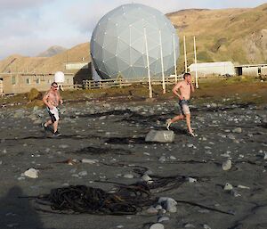 2 men running across the isthmus in front of the ANARE sat