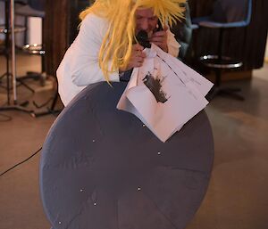 A man sings and holds a grey disk