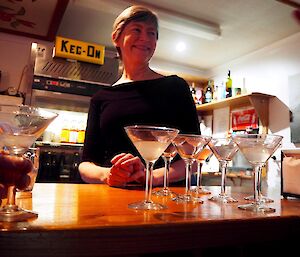 A woman stands behind a bar