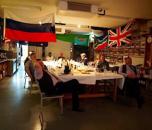 people sitting around a table looking in the direction of a stage