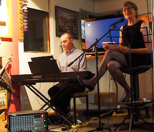 A man on keyboard with a woman singing at a mic