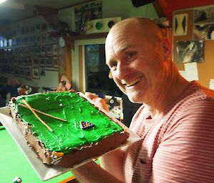 A man holds up a cake