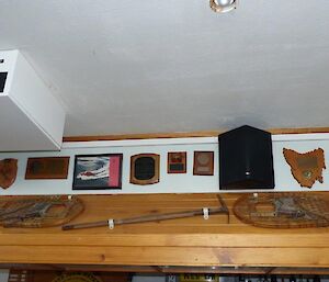 An old pair of snow shoes and ice pick mounted on a wall