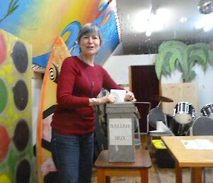 A lady is putting her vote in the ballot box