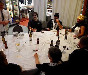 A man makes a speech for the group around the table