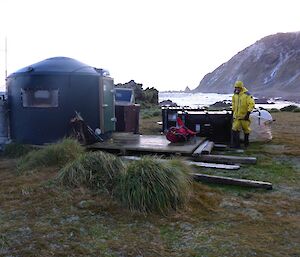 A man by Davis Point hut — which is a converted water tank.