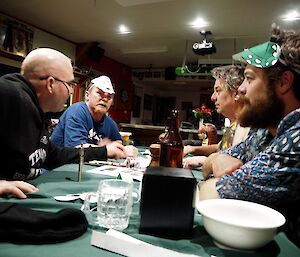 4 men around a table talking