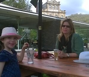 A woman and a child sitting at a picnic table