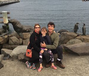 A man, woman and child sitting at the Hobart waterfront