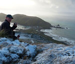 A man enjoys a cup of tea overlooking North Head