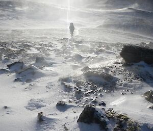 A person walking through the ice and snow on the plateau