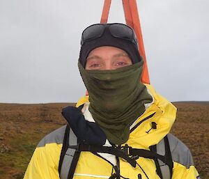 A man looking at camera, with track markers visible in his pack