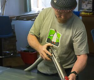 A man working on the slate base of a pool table