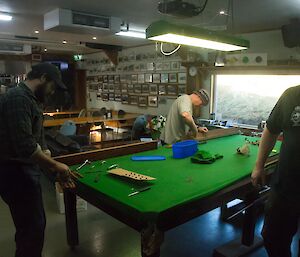 Three men working on the pool table
