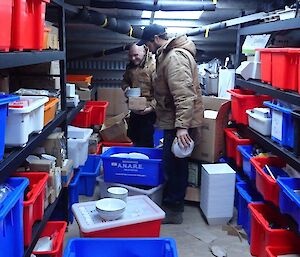 2 men sorting through kitchen stores