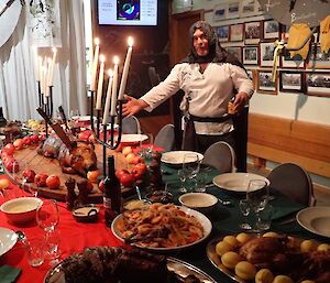 A man in costume surveys the table laden with food