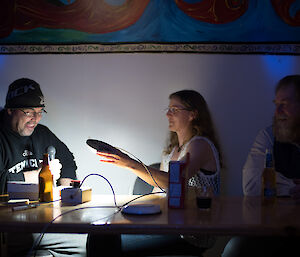 3 people at a table playing a music trivia game